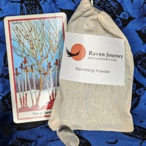 A tarot card sitting next to a bag.