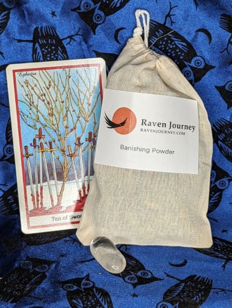 A tarot card sitting next to a bag.