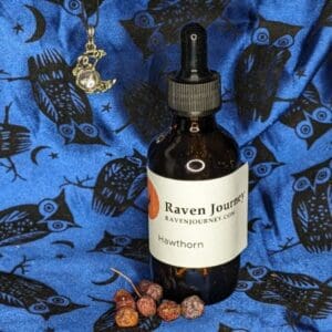 A bottle of raven juice sitting on top of a blue cloth.