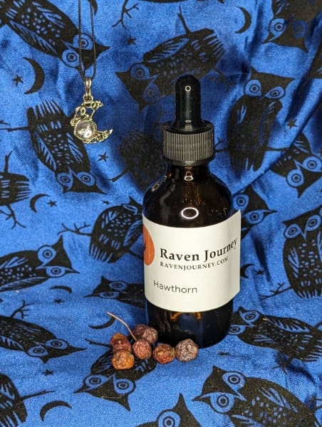 A bottle of raven juice sitting on top of a blue cloth.