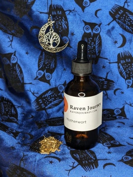 A bottle of raven journey oil sitting on top of a blue blanket.