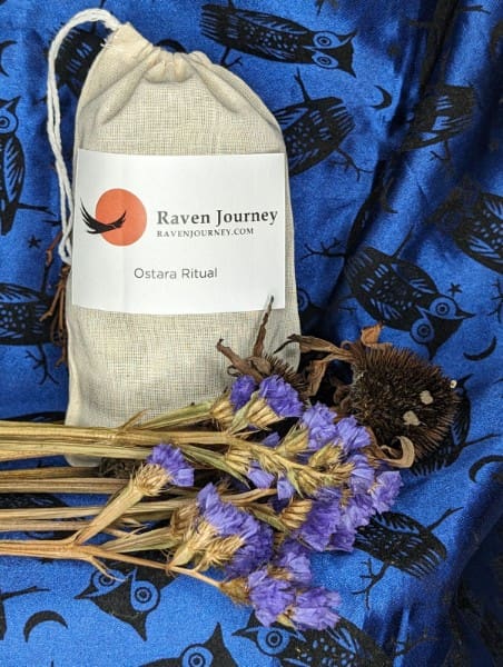 A bag of tea and some flowers on a blue cloth